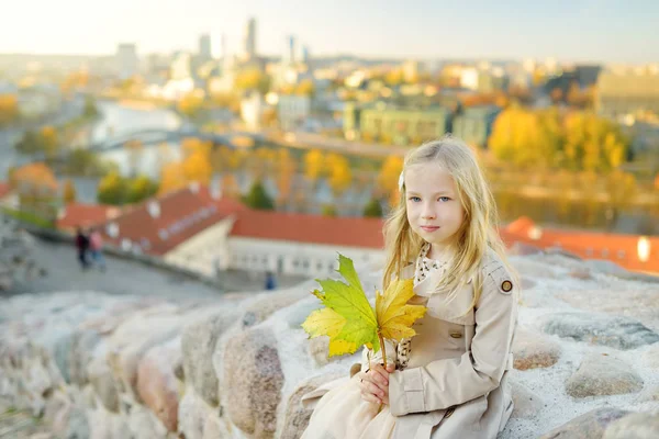Linda niña disfrutando de una vista de la ciudad de Vilna desde la colina de Gediminas en el soleado día de otoño . — Foto de Stock