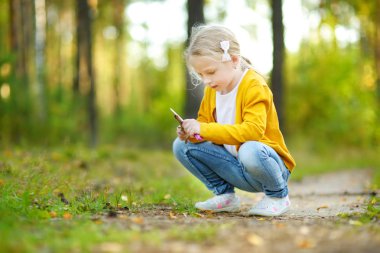 Güzel yaz gününde orman yürüyüşü sırasında eğlenen sevimli genç kız. Doğayı keşfeden çocuk.