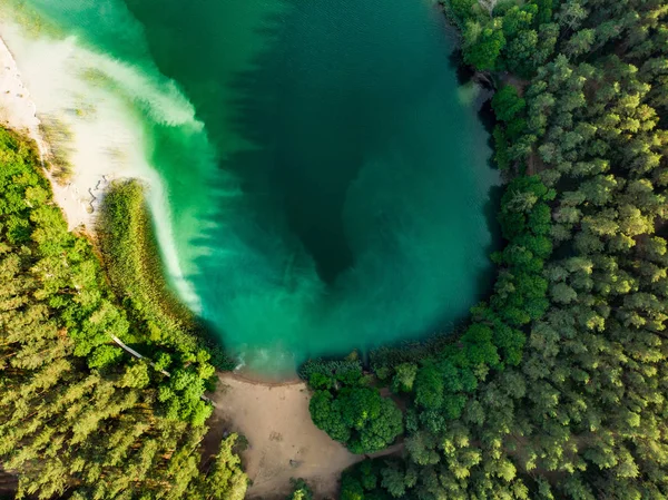 Vista aérea de arriba hacia abajo de las hermosas aguas verdes del lago Gela. Vista panorámica de aves del lago esmeralda rodeado de bosques de pinos . — Foto de Stock