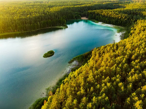Luftaufnahme des schönen grünen Wassers des Gela-Sees. Vogelperspektive auf den malerischen smaragdgrünen See, der von Kiefernwäldern umgeben ist. — Stockfoto