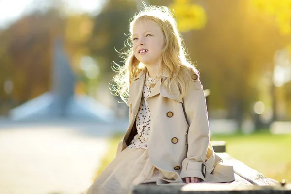 美しい秋の日に楽しみを持っている愛らしい若い女の子。秋の公園で遊ぶ幸せな子供。黄色い紅葉を集める子供. — ストック写真