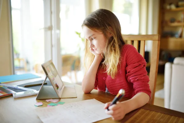 Смарт-підліток робить домашнє завдання за допомогою цифрового планшета вдома. Дитина використовує гаджети для навчання . — стокове фото