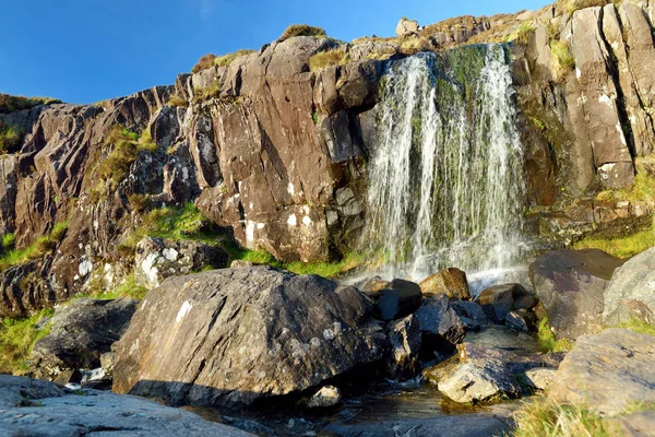 Small waterfall at the Conor Pass, one of the highest Irish mountain passes served by an asphalted road, located on the Dingle Peninsula, County Kerry, Ireland — Stock Photo, Image