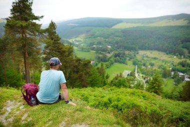 Turist Wicklow Dağları Milli Parkı ormanlık keşfetmek. Glendalough vadisinin eski çam ağaçları ve yemyeşil yeşillikleri, County Wicklow, İrlanda