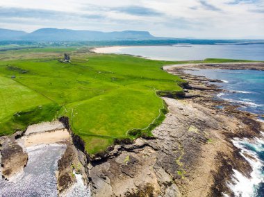 Mullaghmore Head'in muhteşem havadan görünümü ve kıyıya vuran dev dalgalar. Muhteşem Classiebawn Kalesi ile pitoresk sahne.