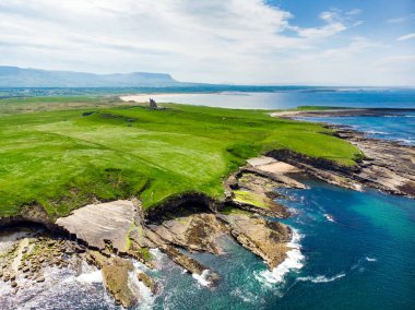 Mullaghmore Head'in muhteşem havadan görünümü ve kıyıya vuran dev dalgalar. Muhteşem Classiebawn Kalesi ile pitoresk sahne.