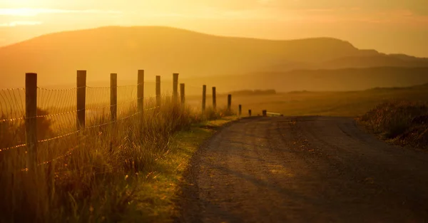 Coucher de soleil dans le Connemara. Route pittoresque de campagne irlandaise menant vers de magnifiques montagnes, comté de Galway, Irlande . — Photo