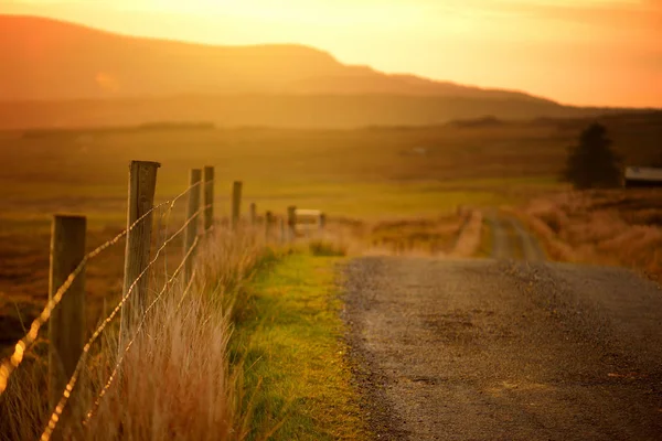 Sonnenuntergang in Connemara. malerische irische Landstraße, die in Richtung herrlicher Berge, County Galway, Irland führt. — Stockfoto