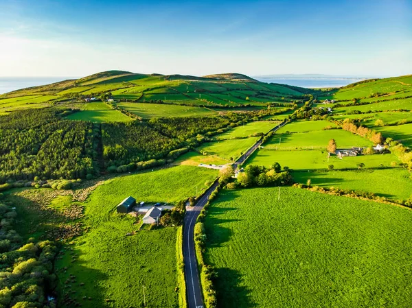 Letecký pohled na nekonečné svěží pastviny a farmlandy Irska. Krásná Irská krajina se zelenými poli a loukami. Venkovská krajina při západu slunce. — Stock fotografie