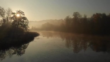 Turuncu ve sarı yeşillik ile sonbaharda güzel sisli göl hava sahnesi