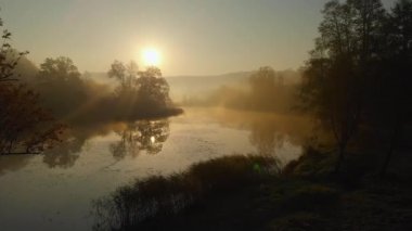 Turuncu ve sarı yeşillik ile sonbaharda güzel sisli göl hava sahnesi