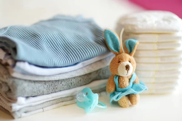 一堆婴儿衣服 一次性尿布 奶嘴和一只玩具兔子 父母费用的概念 制定一个婴儿预算 为新生儿做计划可以省钱 为新生儿编制预算 — 图库照片