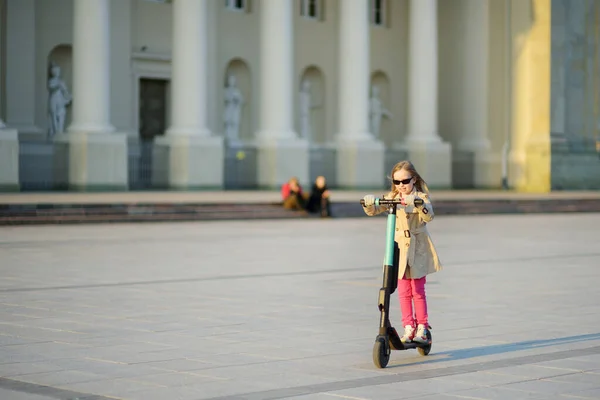 晴れた春の日に電動スクーターに乗ってかわいい若い女の子 リトアニアのヴィリニュスでの電気都市交通 レンタル用のスクーター 子供連れのファミリーレジャー — ストック写真