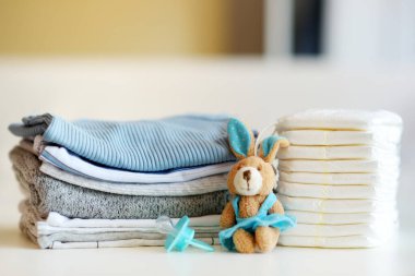 Bebek kıyafetleri, bebek bezleri, emzik ve oyuncak tavşan. Ebeveyn masrafları konsepti. Bebek bütçesi hazırlıyorum. Yeni doğmuş bir bebek için para biriktiriyorum. Yeni bir bebek için bütçe ayırıyorum..
