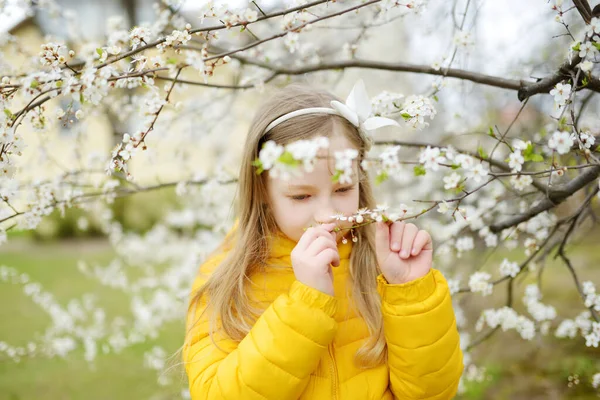 美しい春の日に咲くアップル ツリー庭で愛らしい少女 新鮮なリンゴの木の花をついばんで春かわいい子 — ストック写真