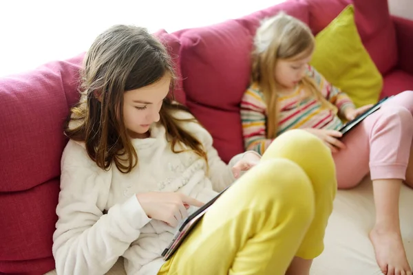 Duas Irmãs Adoráveis Brincando Com Tablet Digital Uma Sala Estar — Fotografia de Stock