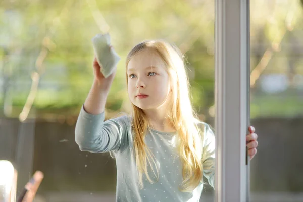 Милая Молодая Девушка Моет Окно Бумажной Тканью Ребенок Помогает Повседневной — стоковое фото