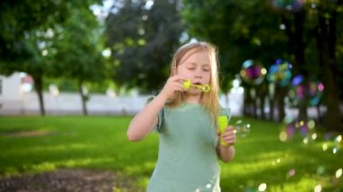 Gün batımında sabun köpüğü üfleyen güzel genç kız.