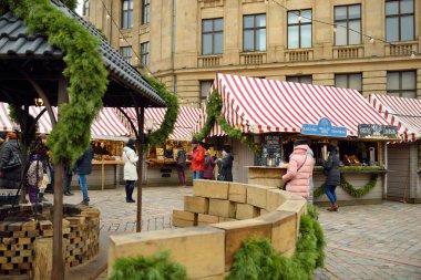 RIGA, LATVIA - 19 Aralık 2019 İnsanlar Riga 'nın en otantik Noel pazarının keyfini çıkarırken düzinelerce el işi ve gıda tezgahı sunuyorlar..