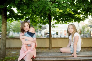 İki abla, tapılası küçük erkek kardeşlerine hayran. İki genç kız yeni erkek kardeşlerini kucaklıyorlar. Geniş yaş farkı olan çocuklar. Kardeşler arasında büyük yaş farkı var. Büyük aile..