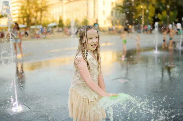 リトアニアのヴィリニュスに新しく改装されたルキス広場で噴水で遊んでかわいい若い女の子 晴れた夏の日に水で楽しんでいる子供 子供のためのアクティブなレジャー — ストック写真