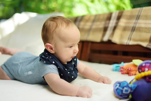 かわいい3ヶ月の赤ちゃん男の子は彼のカラフルなおもちゃの屋外で遊んでいます おなかの中の赤ちゃん かわいい子供は這うことを学ぶ — ストック写真