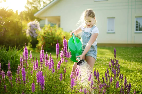 夏天的时候 可爱的小女孩在花园里浇花 孩子们在阳光灿烂的日子里可以用浇水 妈妈的小助手 — 图库照片