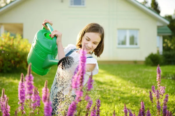 夏天的时候 可爱的小女孩在花园里浇花 孩子们在阳光灿烂的日子里可以用浇水 妈妈的小助手 — 图库照片