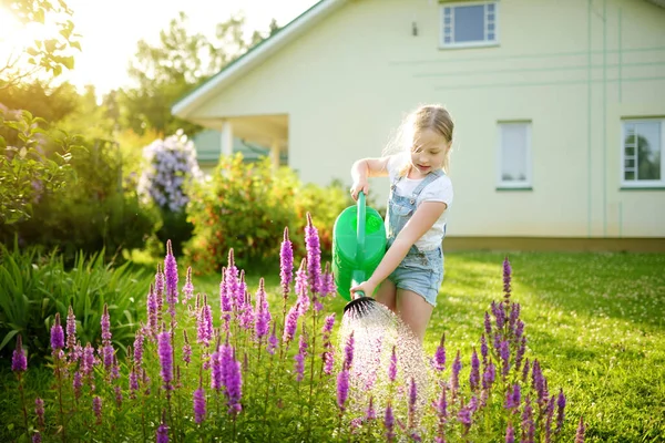 夏の日に庭にかわいい若い女の子が花を咲かせます 散水を使用して子供は晴れた日にすることができます リトル ヘルパー — ストック写真