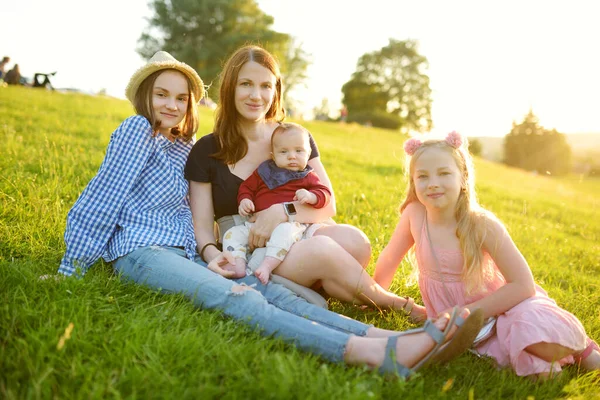 어머니와 자녀는 공원에서 여름날을 즐기고 엄마가 스러운 언니가 엄마와 남동생을 — 스톡 사진