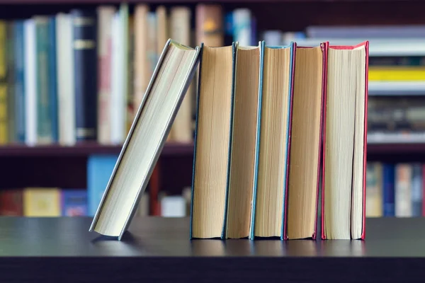 Ein Stapel Bücher Auf Dem Hintergrund Von Bücherregalen — Stockfoto