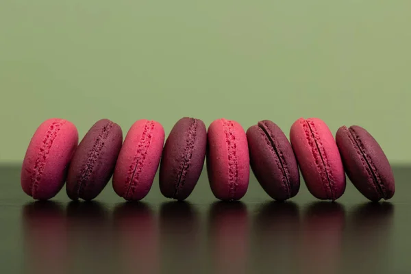 A row of pink and chocolate macaroon pies