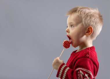 Sevimli küçük çocuk bir lolipop yemek yakın çekim.