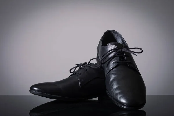 Black classic men's shoes on grey background.