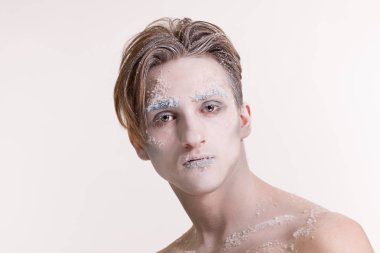 Beyaz arka plan üzerinde kış tarzında yüz sanatı ile güzel genç adam.