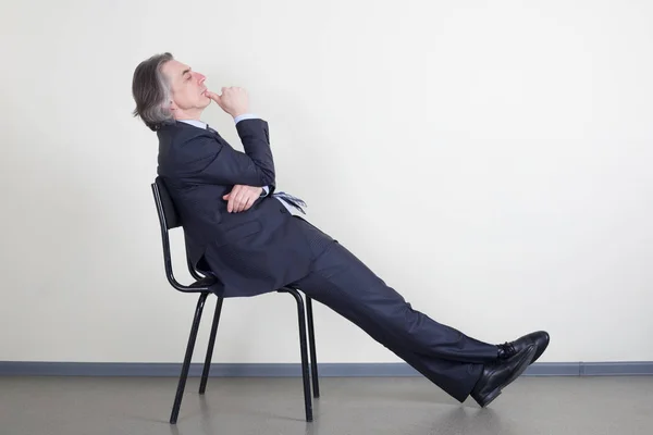 Hombre Negocios Sueña Sentado Una Silla Contra Pared —  Fotos de Stock