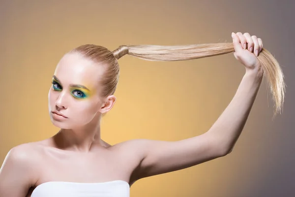 Uma Mulher Bonita Com Maquiagem Brilhante Puxa Seu Cabelo Loiro — Fotografia de Stock