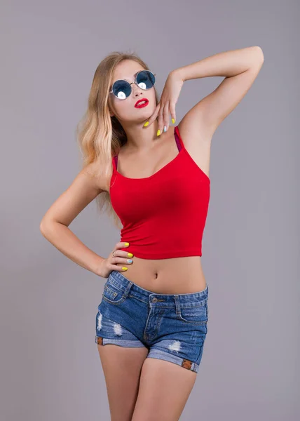 Stylish Young Woman Sunglasses Red Top Denim Shorts Posing Gray — Stockfoto