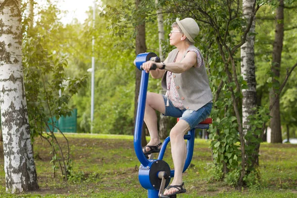 Happy Elderly Woman Leads Active Lifestyle Practicing Simulators City Park — Stock Photo, Image