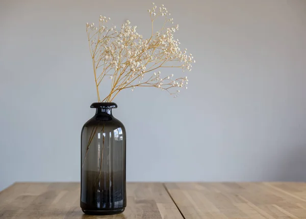 Vaso Vidro Escuro Com Uma Flor Seca Fica Uma Superfície — Fotografia de Stock