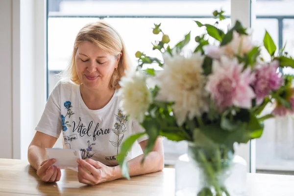 Een Oudere Vrouw Kijkt Liefdevol Naar Een Foto Van Haar — Stockfoto