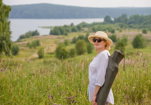 Starsza Kobieta Eleganckim Słomkowym Kapeluszu Podróżuje Przyrodzie Ciesząc Się Krajobrazem — Zdjęcie stockowe