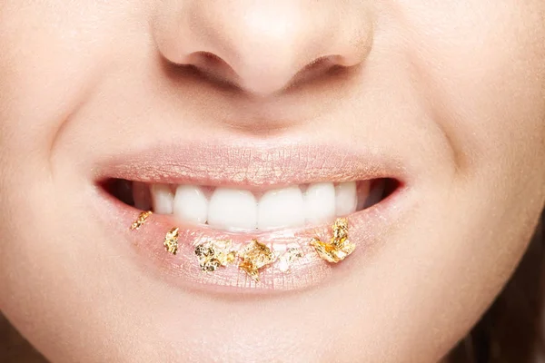 Female mouth with sparkles on lips. Closeup macro beauty portrait of young woman face.