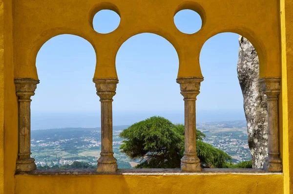 The view through the arabian style arches of the terrace to the surroundings of  Pena Palace. Sintra. Portugal