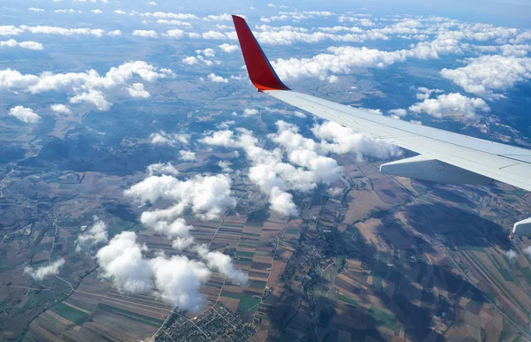 The air view of countryside of Setubal with its fields and road junctions through the clouds from the board of the plane. Lisboa. Portugal