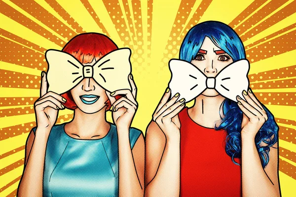 Portrait of young women in comic pop art make-up style. Females in red and blue wigs on yellow - orange cartoon background. Girls with yellow bow-tie in hands