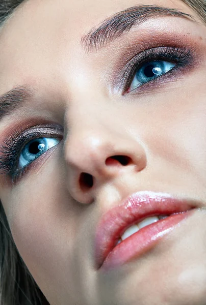 Closeup macro shot of human woman face. Female with smoky eyes makeup