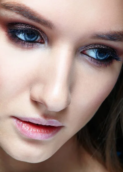 Closeup macro shot of human woman face. Female with smoky eyes makeup