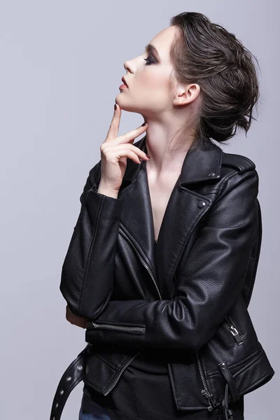Portrait of female in black leather jacket. Woman with unusual beauty evening makeup. Girl with perfect skin and violet - black shadows make-up.