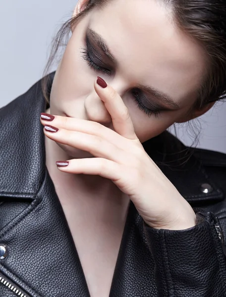 Portrait of female in black leather jacket. Woman with unusual beauty evening makeup. Girl with perfect skins and violet - black eye shadows make-up.